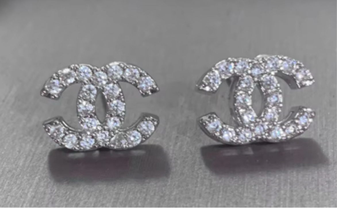 Pendientes con logo de doble C y circonitas en tono dorado.