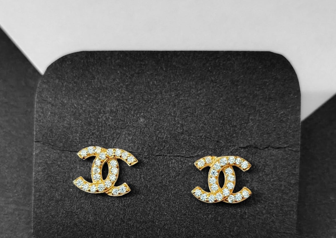 Pendientes con logo de doble C y circonitas en tono dorado.